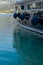 Crop view of luxury motorboat with fenders on calm water parked in the marina, turquoise sea