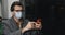 Crop view of man in protective mask and glasses using smartphone. Male stylish person in earbuds scrolling social media