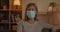 Crop view of mature woman in medical protective mask turning head and looking to camera. Female elderly person with