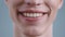 Crop view of young man face while he laughing. Portrait of male model at studio background. Focus on lips.