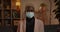 Crop view of young man in medical protective mask turning head and looking to camera. Portrait of millennial guy with