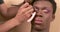 Crop visagiste filling in eyebrows of black transgender