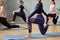 Crop of women practicing yoga in hall.