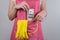 Croped close up photo of woman hiding 100 dollars into pocket of her apron isolated grey background