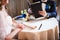 Croped picture of newlyweds sitting at table in cafe, groom looks at menu.