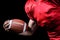 Cropped American football player holding ball