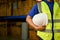 Cropped, Asian male warehouse supervisor or worker in uniform holding a white hardhat