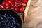 Cropped bowl of blueberries and box, crape of red sweet cherries with tail on craft wrinkled old paper background