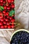 Cropped bowl of blueberries and box, crape of red sweet cherries with tail on craft wrinkled old paper background