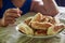 Cropped child reaches out and takes a fried pie with sausage from a plate,