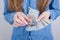 Cropped close-up photo of girlish beautiful hands with long nails pink bright manicure on fingers holding calculating old money