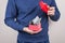 Cropped close-up photo shot of student holding small red little package full of money isolated grye background