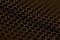 Cropped close up photo of small golden hexagon background holes