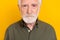 Cropped close up portrait of calm concentrated person look camera isolated on yellow color background