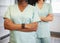 Cropped close up of two healthcare professionals wearing scrubs with arms folded