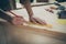 Cropped close-up view of his he nice professional skilled hardworking guy making marks measuring board plank building