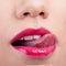 Cropped closeup of a woman wearing lipstick and licking her lip