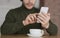 Cropped of guy using smartphone and cup of coffee