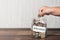 Cropped hand of a toddler putting coin into jar full of coins