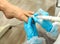 Cropped head portrait of doctor podiatry in blue gloves doing medical treatment on the fingers in medical center