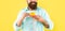 cropped hipster with beard holding coffee cup on yellow background, cappuccino