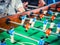 Cropped image of active people playing foosball. table soccer plaers. Friends play together table football