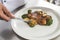 cropped image of african american chef putting piece of zucchini on plate