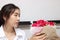 Cropped image of attractive young Asian woman accepting a bouquet of red roses from boyfriend in office on valentine`s day. Love