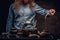 Cropped image of a bearded redhead male in a blue shirt preparing tea using a handmade tea set.