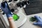 cropped image of biologist examining green leaf under microscope at table with laptop in agro laboratory