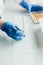 cropped image of biologist putting seeds in row by tweezers at table in modern