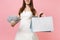 Cropped image of bride woman in wedding dress holding bundle lots of dollars cash money, multi colored packages bags