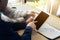 Cropped image businessman sitting at the table with cup of coffee, digital tablet and smart phone, businessman hands typing