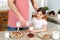 Cropped image of careful father wears apron, pours fresh milk in glass for his daughter, bakes delicious pancakes