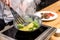 cropped image of chef stirring bell peppers with broccoli