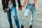 Cropped image of couple in stylish shoes and jeans standing together on one longboard