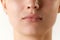 Cropped image of female face, lips and nose over white background. Lip augmentation and anti-wrinkle fillers