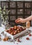 cropped image of female hand and pile of lychees in wooden box