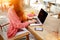 Cropped image of a female keyboarding on laptop computer with copy space screen while sitting in cafe outdoors,