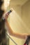 Cropped image hand of young woman holding shower faucet in bathroom