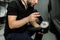 Cropped image of hands of male auto service worker, applying special polish wax or cream on the orbital polish machine