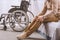 cropped image of man with disability sitting on bed and touching legs