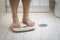 Cropped image of man feet standing on weigh scale