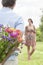 Cropped image of man surprising woman with bouquet in park