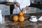 Cropped image of mixed race girl in white robe cutting oranges in morning