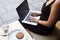 Cropped image of modern businesswoman work in internet via net-book while resting in cafe outdoors