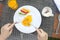 Cropped image of person eating eggs benedict at a cafe table