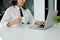 Cropped image, Professional Asian aged female manager sipping coffee while using laptop