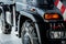 Cropped image. Right side of the car. Jeep with snow chains parked indoors at the white tile on vehicle show