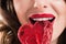 cropped image of seductive girl biting heart shaped lollipop, valentines day